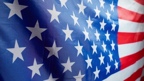 USA national flag close-up, camera moving back. Unites States of America flag, cam motion from stars to full size, textured fabric.