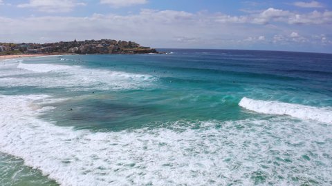 Surfers on waves of Bondi beach. Sydney ocean coast summer landscape