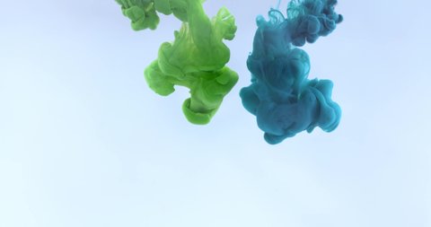 Green and blue color paints ink drops in water in grey background, slow motion of beautiful paint abstract falling. 4K.