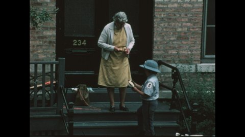 1970s: City building stoop, boy wears postal service uniform, hands letters to woman. Mail truck drives, pulls up to curb.