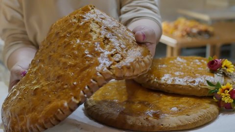 a woman holding with both hands breaks a fresh hot Armenian gata into two parts. We break in half the Azerbaijani kata baked in tonir. Close up, slow motion