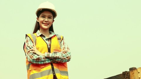 Portrait beautiful young asian female industrial engineer  working diesel locomotive train station standing next to an old railway bogie looking at the camera smiling greeting at you