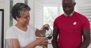 Animation of vegan food text over senior african american couple with healthy drink. senior home hangout and digital interface concept digitally generated video.