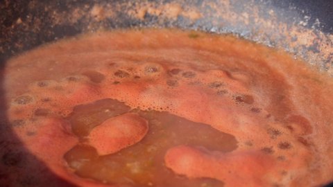 Cooking ketchup or tomato sauce or tomato soup in pan, Italian cuisine, food and drink. Selective focus