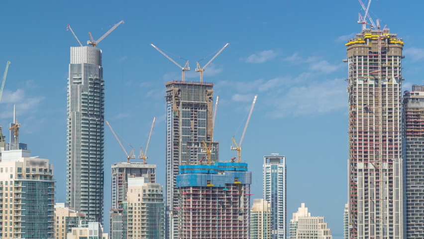 New construction site and futuristic aerial cityscape timelapse with modern architecture of Dubai downtown. Tall skyscrapers and towers.