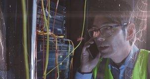 Animation of lights over asian man with smartphone working in server room. network, programming, computers and technology concept digitally generated video.