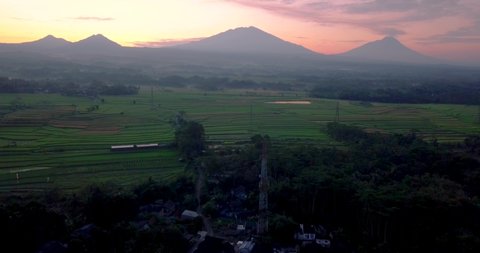 Flight over the countryside in Indonesia with the view of Mount Telemoyo, Andong, Merbabu and Merapi during sunrise