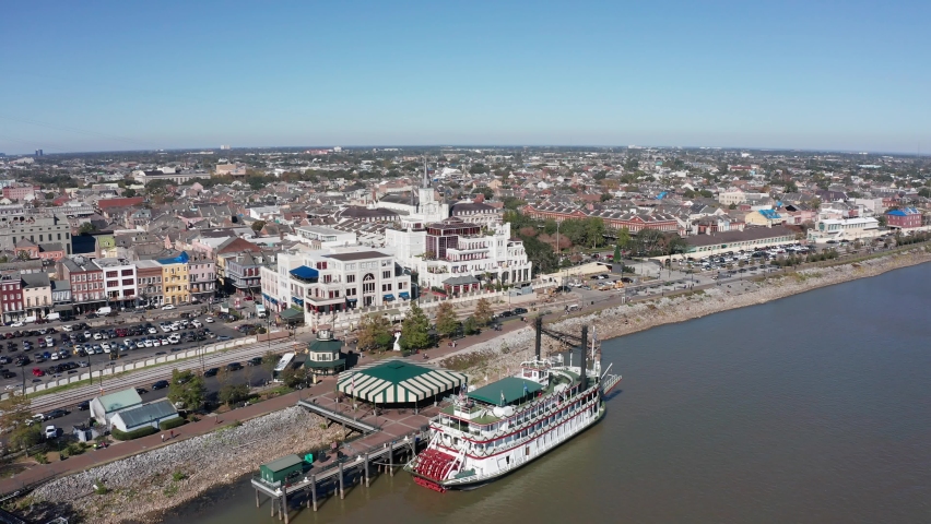 Aerial descending close-up shot of a steamboat along the Mississippi River in the French Quarter. 4K