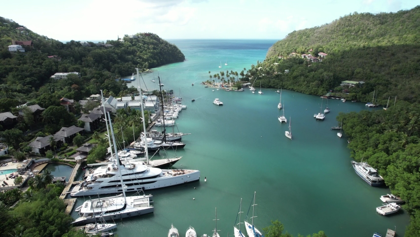 Superyachts docked in Marigot Bay. A beautiful hidden gem along St.Lucia's coastline, full of iconic postcard views. Paradise on Earth. Royalty-Free Stock Footage #1090456247
