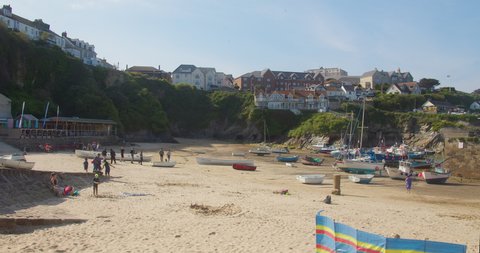 Newquay , Cornwall , United Kingdom (UK) - 05 08 2022: Families Enjoying The Sandy Beach Of Newquay Harbour In Cornwall, England With The Boathouse Restaurant, Harbour Hotel And Boats In The Backgroun