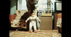 Mother helping child to walk in room. First baby steps, mother holding child in Soviet apartment interior. Vintage color film. Cinema lens flare. Retro 80s, 90s. Family home archive 8mm. 1980s-1990s