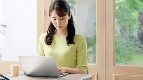 Young Asian woman working with a laptop PC in the room.