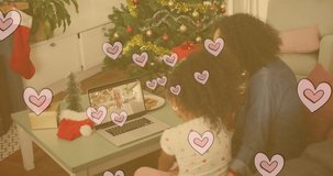 Animation of hearts over biracial mother and daughter having video call. national sons and daughters day and celebration concept digitally generated video.