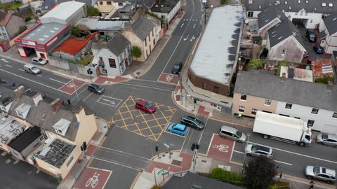 High angle view of street and crossroads in town. Various buildings along road. Cars driving in town centre. Ennis, Ireland