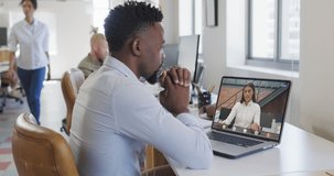 African american businessman using laptop for video call with biracial business colleague. business communication technology and digital composite video.
