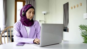 Portrait of muslim operator business woman working with headset and laptop computer, watch webinar listen online course communicate by conference video call, social distance