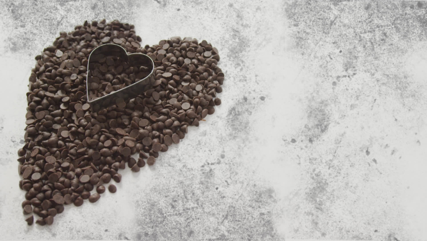 Animation of chocolate crisps and heart shape mold over white and grey background. sweets, desserts and chocolate concept digitally generated video. | Shutterstock HD Video #1090474077