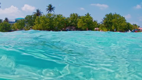 Woman in white mask swimming and snorkeling in the tropical sea in Maldives