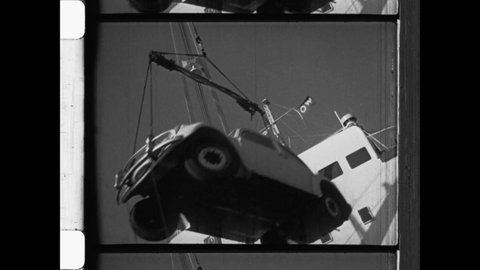 1953 Stockholm, Sweden. A New Volkswagen Beetle arrives at the Port of Trelleborg. The VW Bug is moved to dock by crane. 4K Overscan of 16mm Archival Newsreel Film print