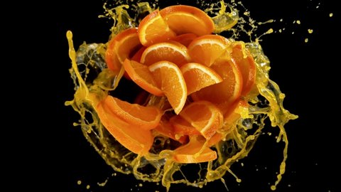 Super slow motion of rotating orange slices with splash juice, black background. Filmed on high speed cinema camera, 1000 fps. Speed ramp effect. Video Stok