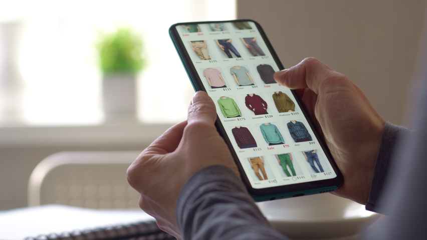 Buying clothes in the online store using the application in the smartphone. E-commerce concept. | Shutterstock HD Video #1090481485