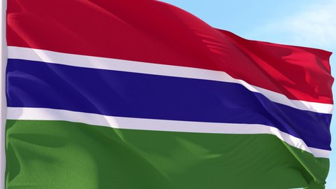 Gambia Flag Looping Background fluttering in the wind against a blue sky on a seamless loop.