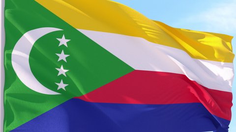 Comoros Flag Looping Background fluttering in the wind against a blue sky on a seamless loop.