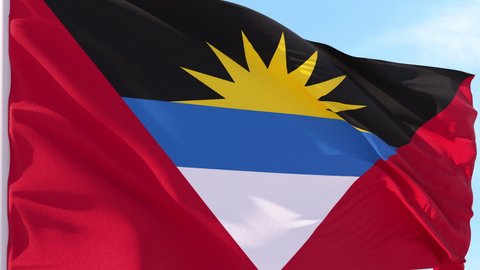 Antigua and Barbuda Flag Looping Background fluttering in the wind against a blue sky on a seamless loop.