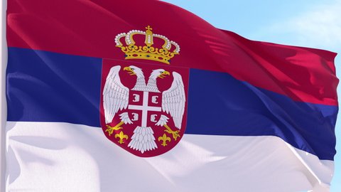 Serbia Flag Looping Background fluttering in the wind against a blue sky on a seamless loop.