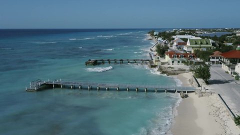Drone camera whirls above a pier in Cockburn Town, aerial view video of Grand Turk coastline, Turks and Caicos
