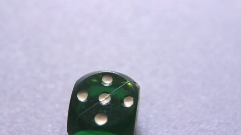 Rolling dice stops on digit 5, object close up