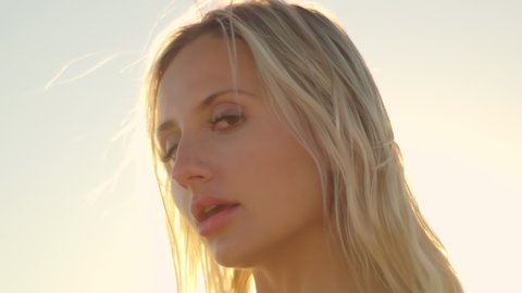 Close up of of a beautiful blonde at sunset on the ocean. Attractive sexy girl