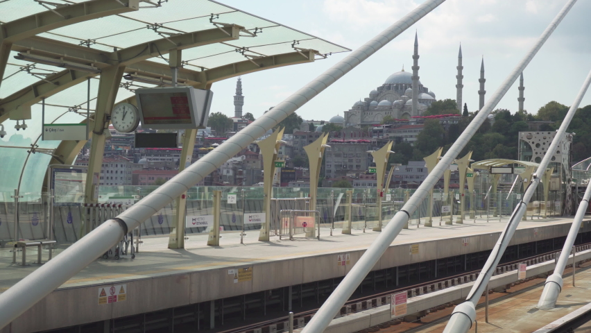 Train of the Istanbul Metro is approaching the Halic Station on the Golden Horn Metro Bridge in Istanbul, Turkey. The Suleymaniye Mosque is visible in background.