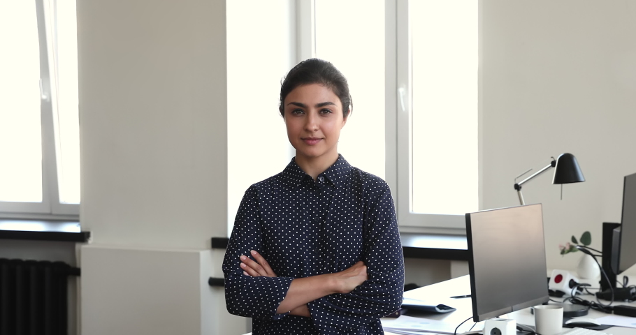 Head shot portrait happy smiling motivated millennial Indian business lady worker executive standing in office with arms crossed on chest. Successful young woman employee proud of working at company Royalty-Free Stock Footage #1090496111