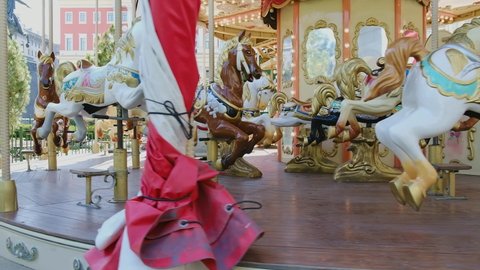 Children's vintage carousel with figures of horses. A working carousel without people. Colorful fair carousel on the square.