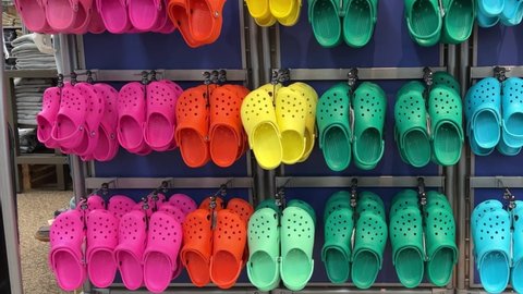 Springfield, IL USA - May 2, 2022: Panning left on rows of Crocs shoes at the Scheels Sporting Goods store in Springfield, Illinois.