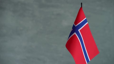 State flag of Kingdom of Norway waving on gray background. Norwegian flag and place for text