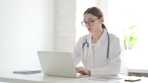 Female Doctor Thinking while Working on Laptop in Office