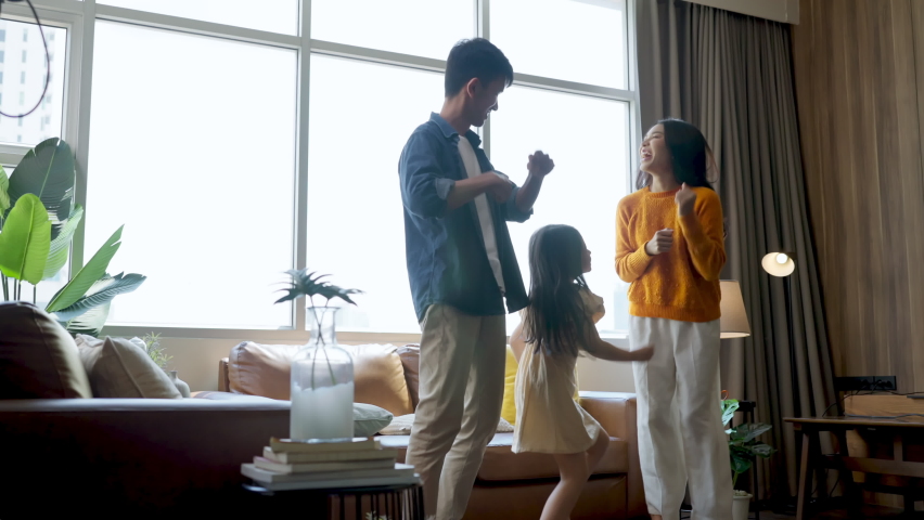 happiness cheerful moment young asian family dad mom daughter spending happiness time dancing together in living room at home,social media activity funny family dance with laugh smile and freshness Royalty-Free Stock Footage #1090507037