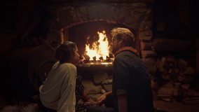 Romantic couple sit fireplace in country house. Two joyful lovers enjoy cozy home interior. Relaxed girlfriend boyfriend flirt together in evening. Young people talk on winter holiday. Comfort concept - Powered by Shutterstock - Get 15% off with code: PIKWIZARD15
