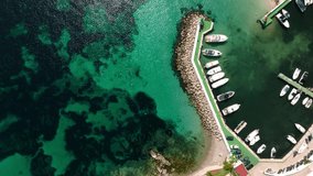 Aerial drone top down video of small emerald sea tropical port with anchored boats located in tropical Caribbean island coral reef