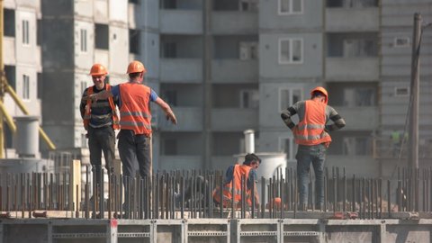 Kyiv,Ukraine - 24.04.2019: Fast motion of buidling construction workers installing a wire. Team of workers doing electrical installation.