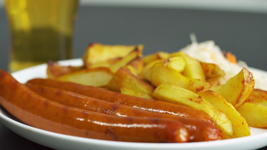 Close up of plate with tasty sausages and flag of Germany. German national food. Glass of beer on the background. Royalty-Free Stock Footage #1090511123