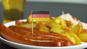 Close up of plate with tasty sausages and flag of Germany. German national food. Glass of beer on the background. - Powered by Shutterstock - Get 15% off with code: PIKWIZARD15