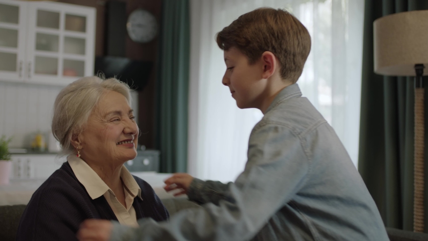 The little boy,who comes to visit his old grandmother, hugs his grandfather.The cute old woman was very happy to see her granddaughter. hug each other.Portrait of loving grandmother and granddaughter. Royalty-Free Stock Footage #1090511803