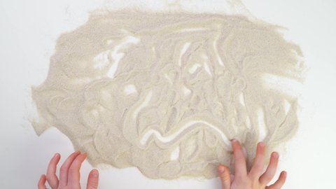 line child finger draw in sand. picture Top view draw on the sand. Caucasian hands write text in beige sand. Vacation and travel. Beach on vacation. Sand painting. Creativity from natural materials.