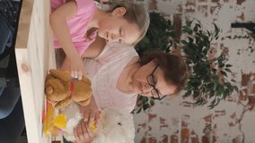 Vertical Video. Little Girl with Grandmother Playing with Toys Together in the Kitchen. Happy Family and Generation Concept