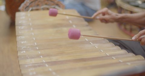 Thai musical instruments. The alto xylophone make a soft sound accompaniment to the rhythm of the music. ( close up hands )