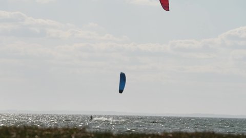 Kiteboarding or Kitesurfing, Blue and Red Kiter, Long Shot, Slow Motion