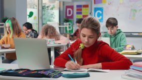 shot of A young girl is teaching a group of Indian Asian primary school children or kids sitting and studying together using a laptop in an indoor classroom setup. learning and education concept. High - Powered by Shutterstock - Get 15% off with code: PIKWIZARD15